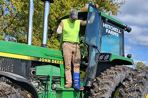 John Mitchell, who lost most of his right arm in a farm accident in September 2022, steps out of his family farm tractor