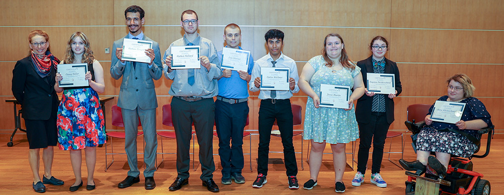 DWD Assistant Deputy Secretary Jennifer Sereno (left) with Project SEARCH graduates at Mayo Clinic in Eau Claire. From left to right are Casey Heller, Nathan Zirngibl, Nathen Helland, Cole Warner, Carlos Wollmer, Jessa Martin, Raynna Heiderscheid, and Chloe Kleinschmidt.