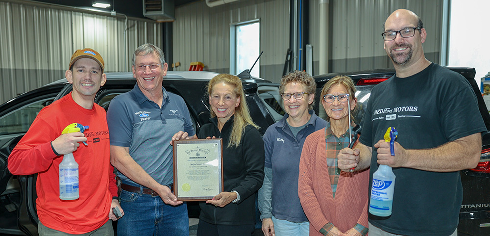 Dustin Phillips, far left, and Michael Paulson, far right, were hired to work at Medford Motors and helped the company celebrate receiving an Exemplary Employer Award at an Oct. 10 event.
